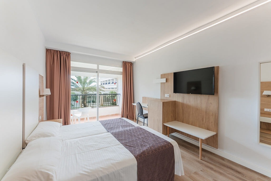 una habitación de hotel con una cama y una televisión