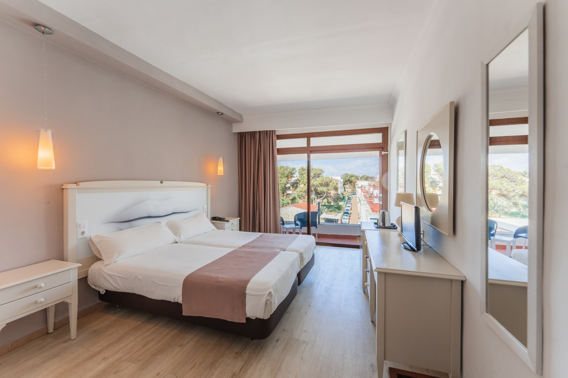 a hotel room with two beds and a flat screen tv