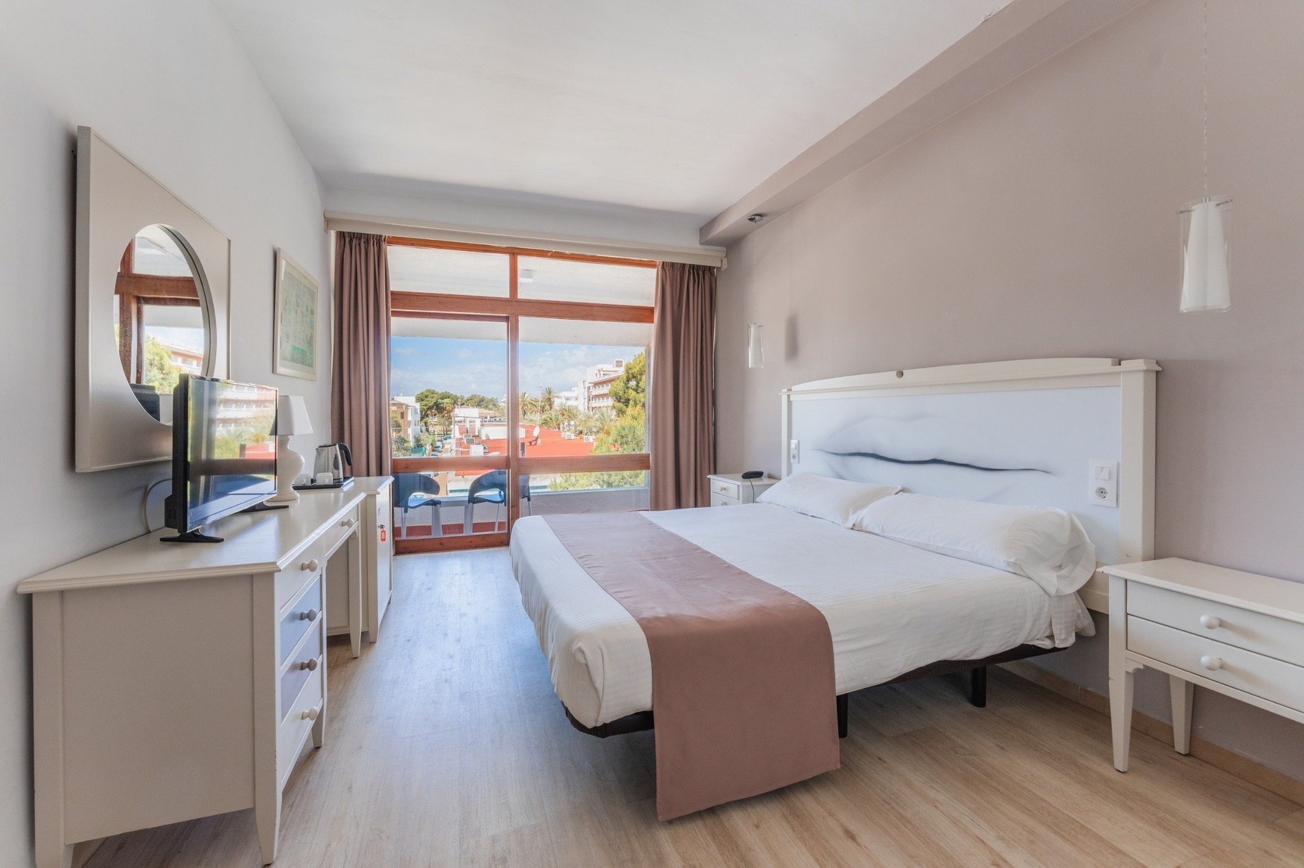 a hotel room with two beds and a flat screen tv