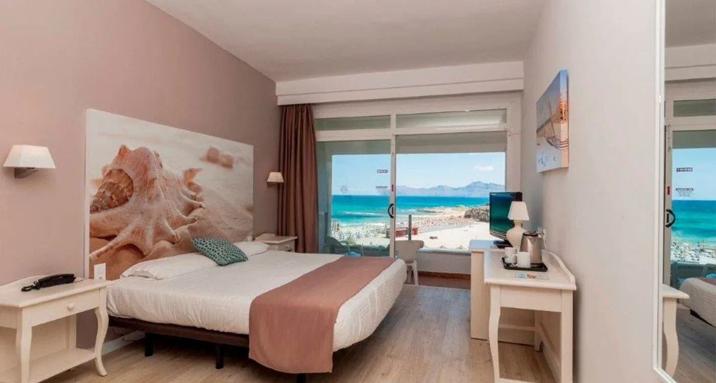 a hotel room with a large bed and a view of the ocean