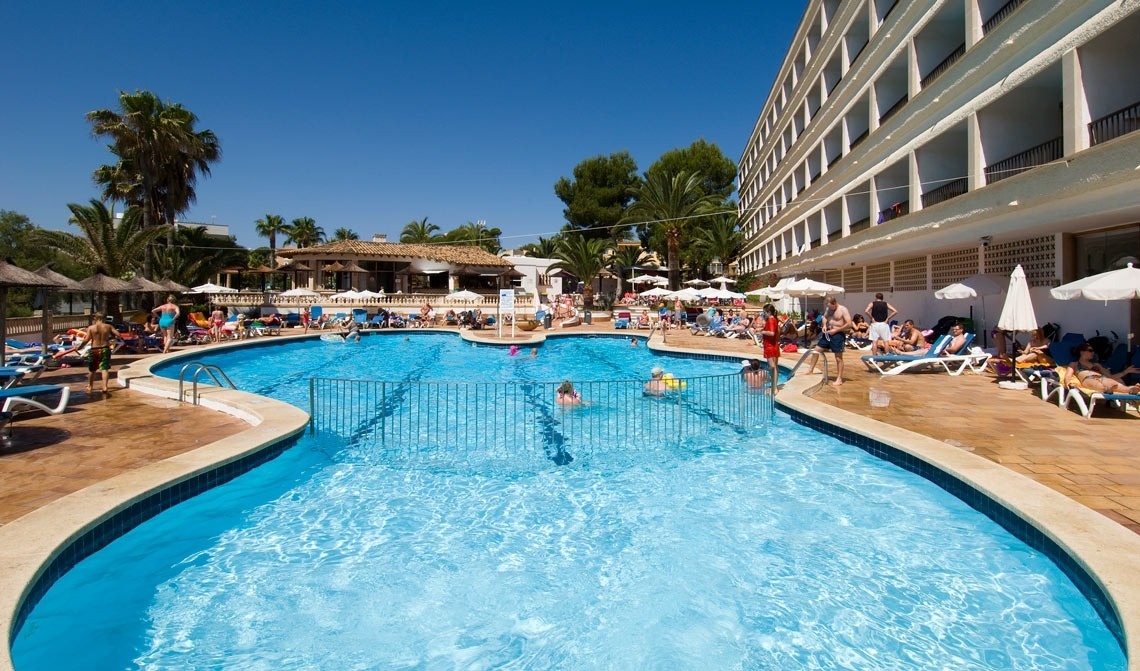 una persona está sentada en una mesa con platos de comida y bebidas .