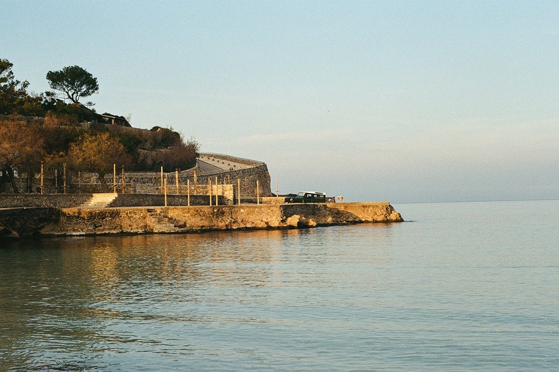 a few boats are in the water near a small island