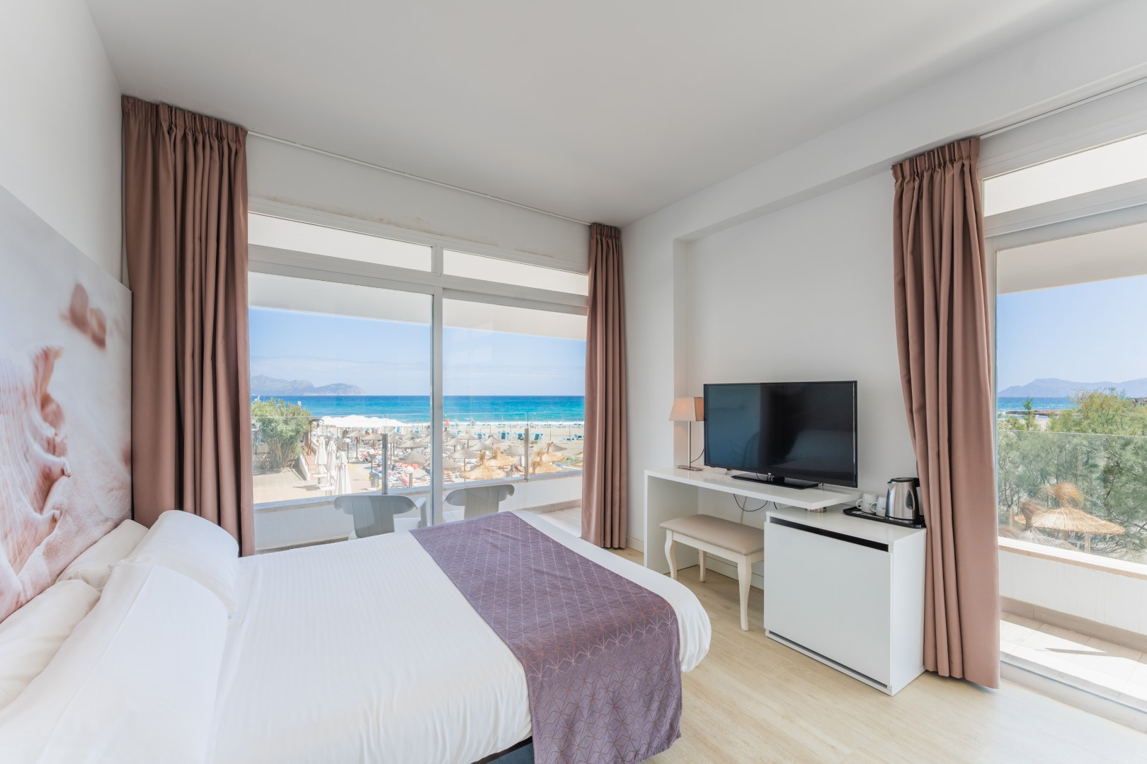 a hotel room with a large bed and a flat screen tv
