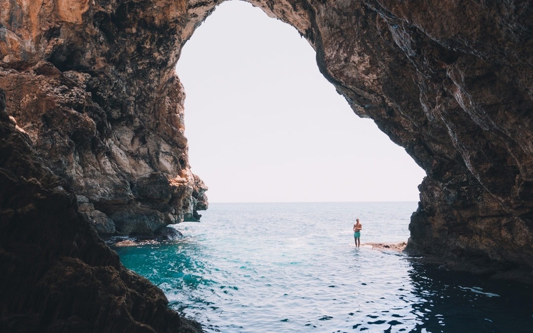 a man walking a dog on a sandy beach