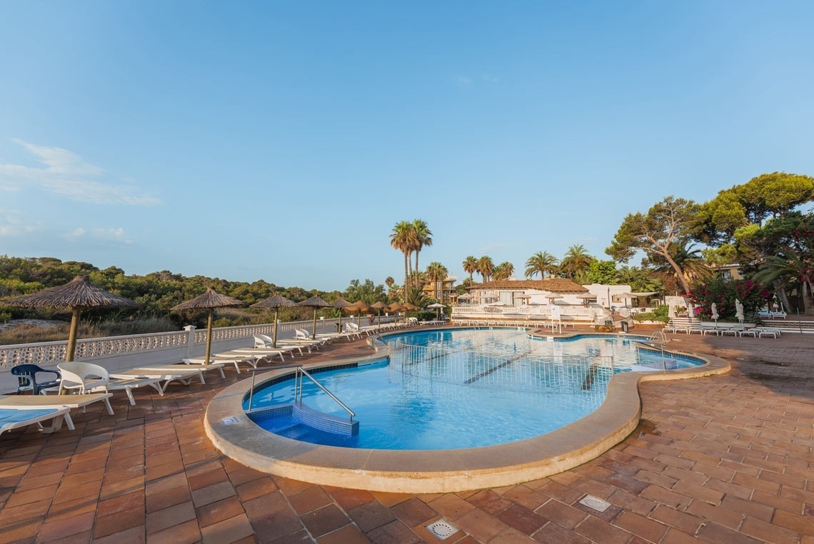 una persona está sentada en una mesa con platos de comida y bebidas .