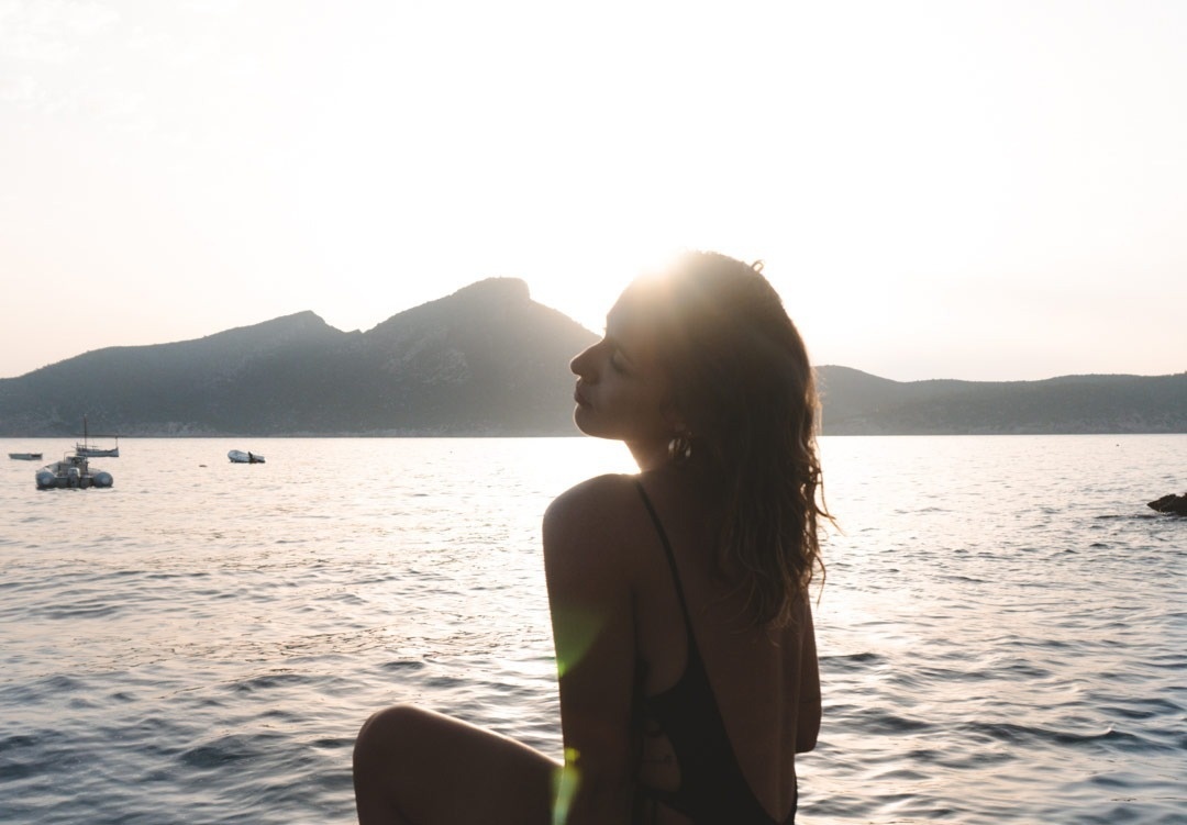 a few boats are in the water near a small island
