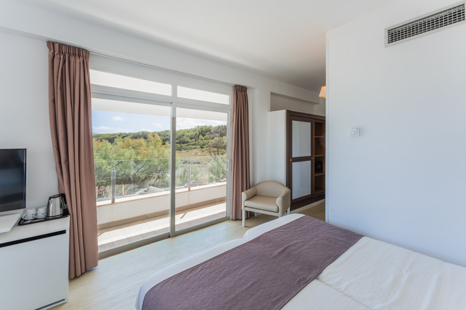 a hotel room with two beds and a flat screen tv
