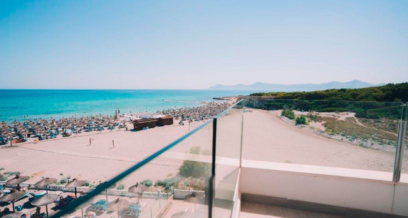 a view of a beach from a balcony with umbrellas