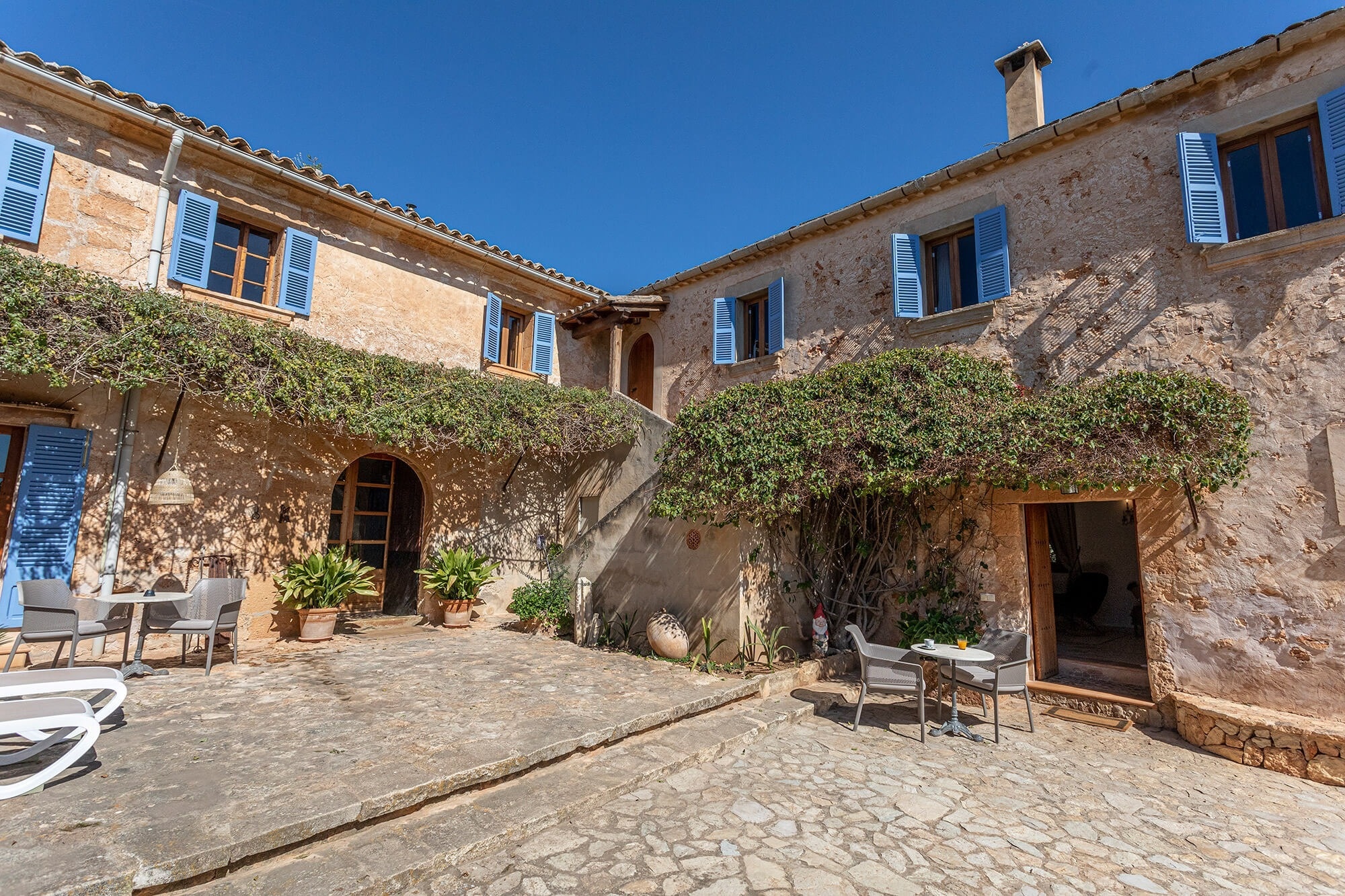 una antigua casa de piedra con persianas azules en las ventanas