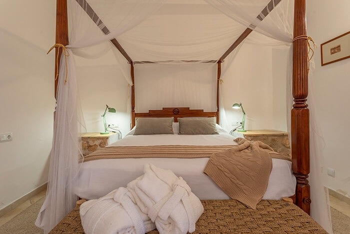 een bed met een baldakijn ligt in een slaapkamer