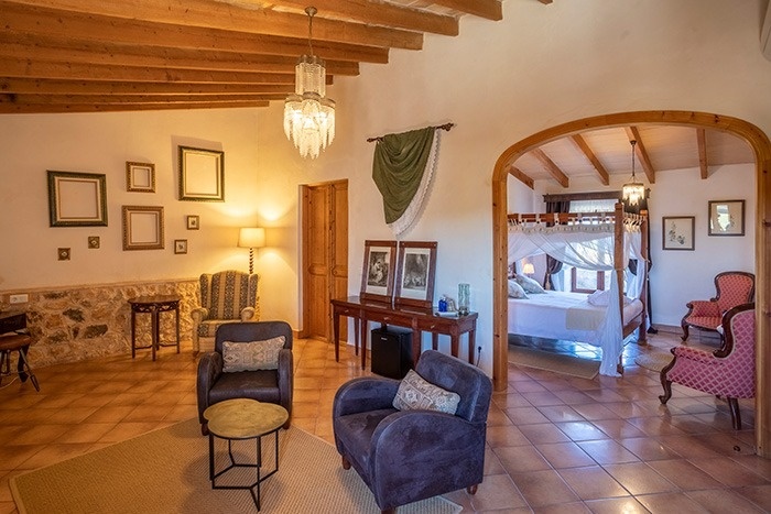 een woonkamer met stoelen en een bed met een baldakijn