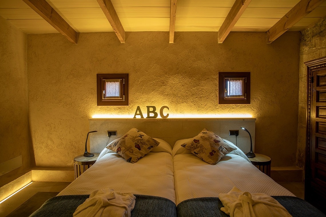 een slaapkamer met twee bedden en de letters abc aan de muur