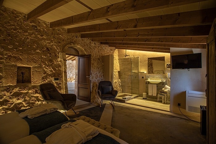 een kamer met een bed en een stoel en een televisie