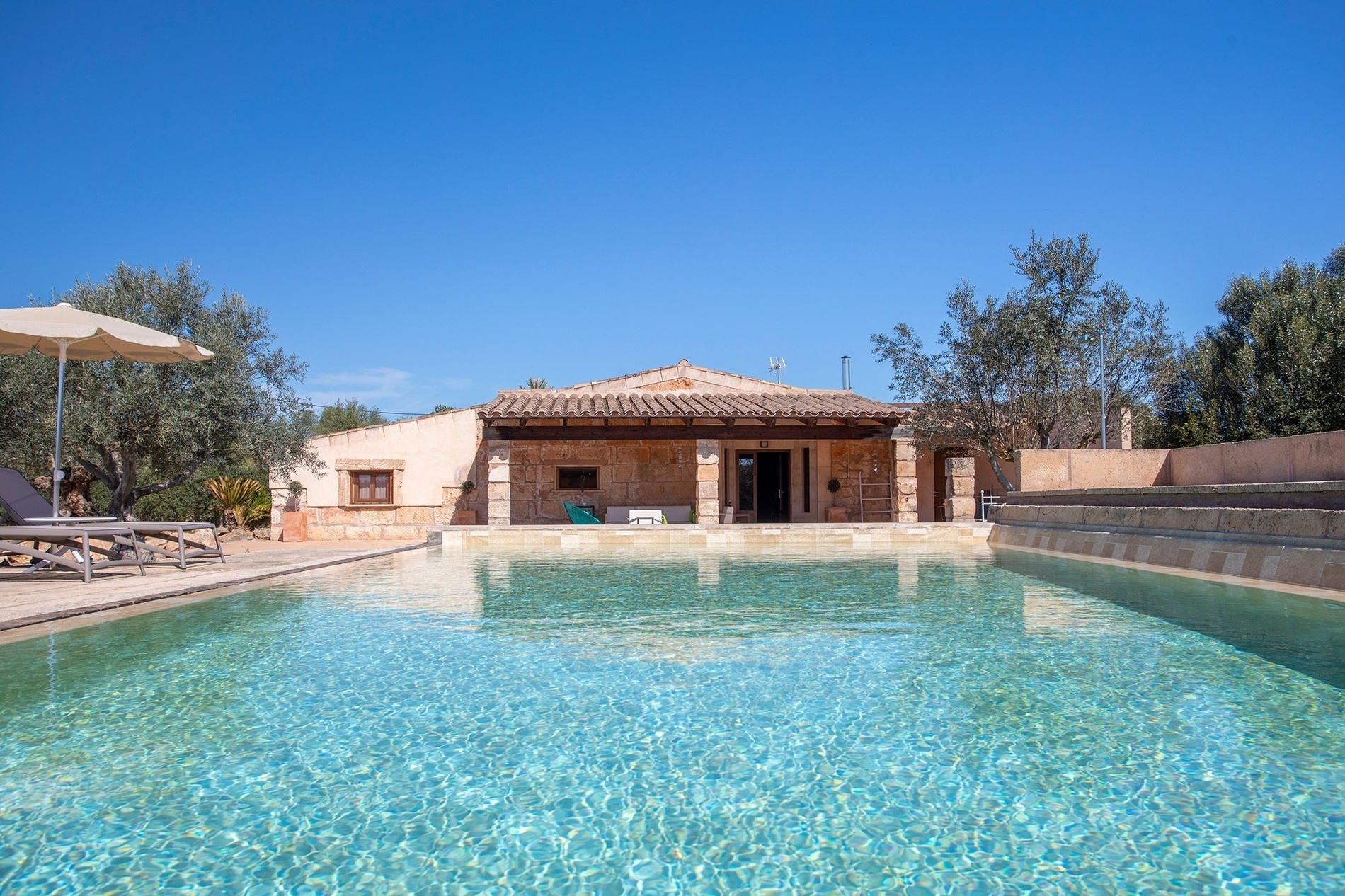una casa de piedra con una piscina al frente