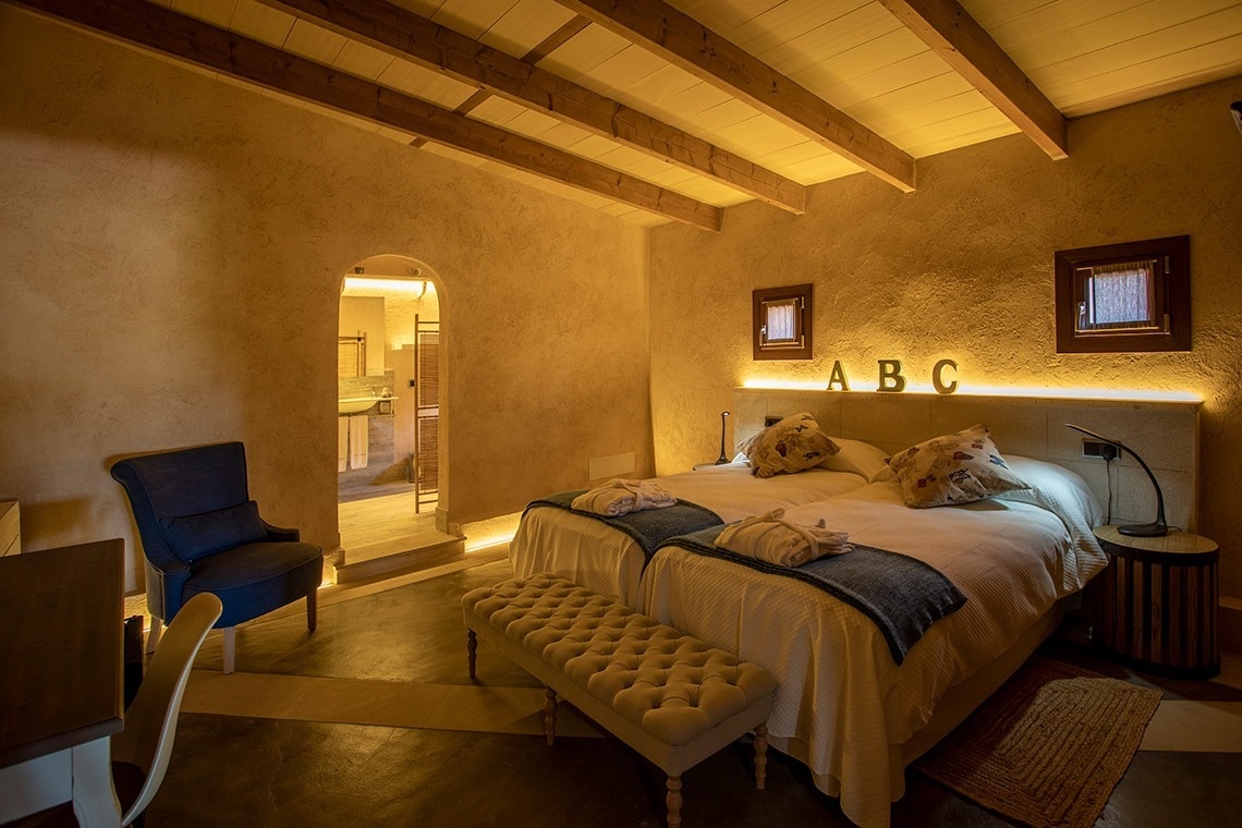 een slaapkamer met twee bedden en de letters abc aan de muur