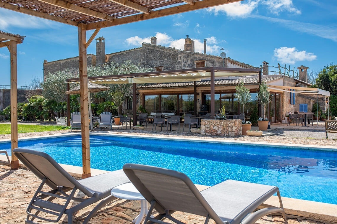 a large swimming pool with a house in the background