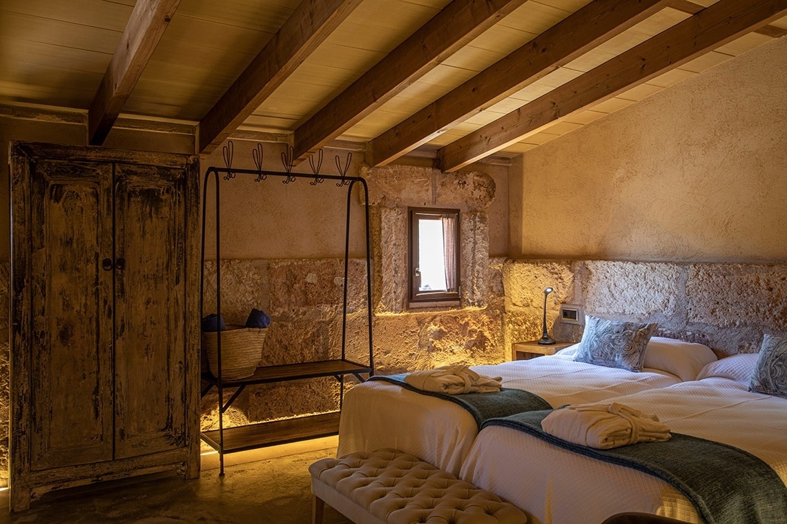 een slaapkamer met twee bedden en een houten kast