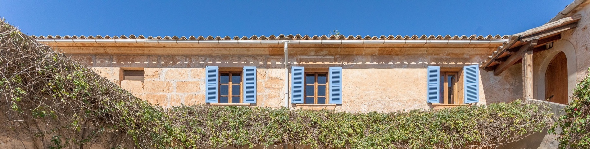 una casa de ladrillo con persianas azules en las ventanas