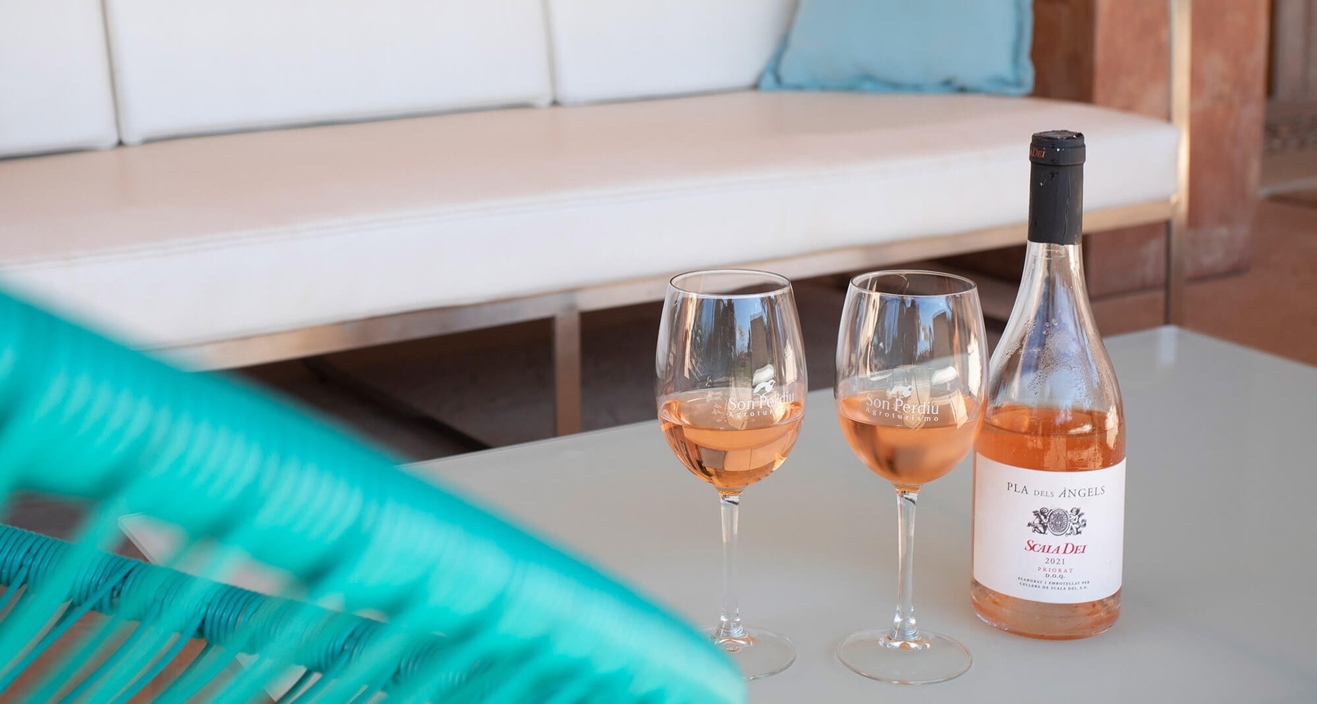 two glasses of rose wine next to a bottle of rose wine