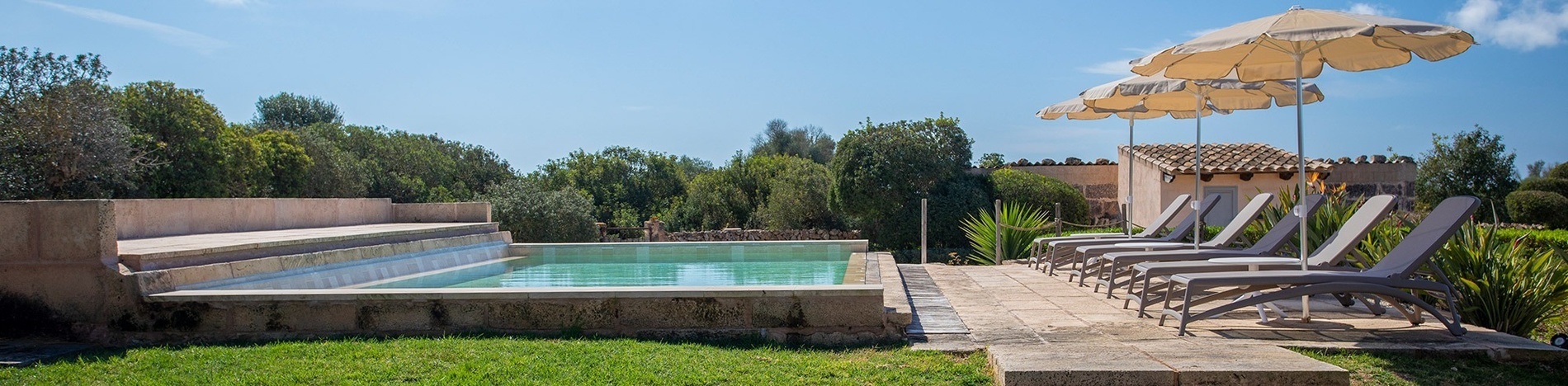 una piscina rodeada de sillas y sombrillas en un día soleado