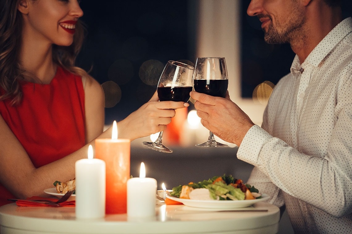 un hombre y una mujer brindan con copas de vino