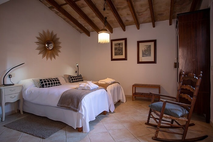 een slaapkamer met twee bedden en een schommelstoel