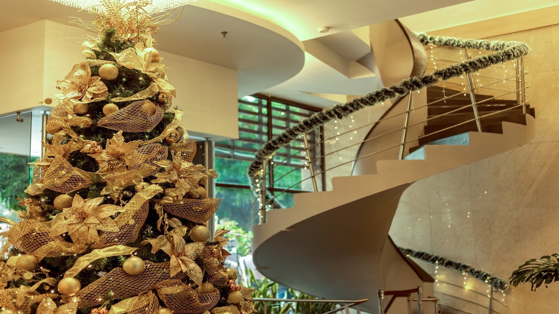 un árbol de navidad está decorado en oro junto a una escalera