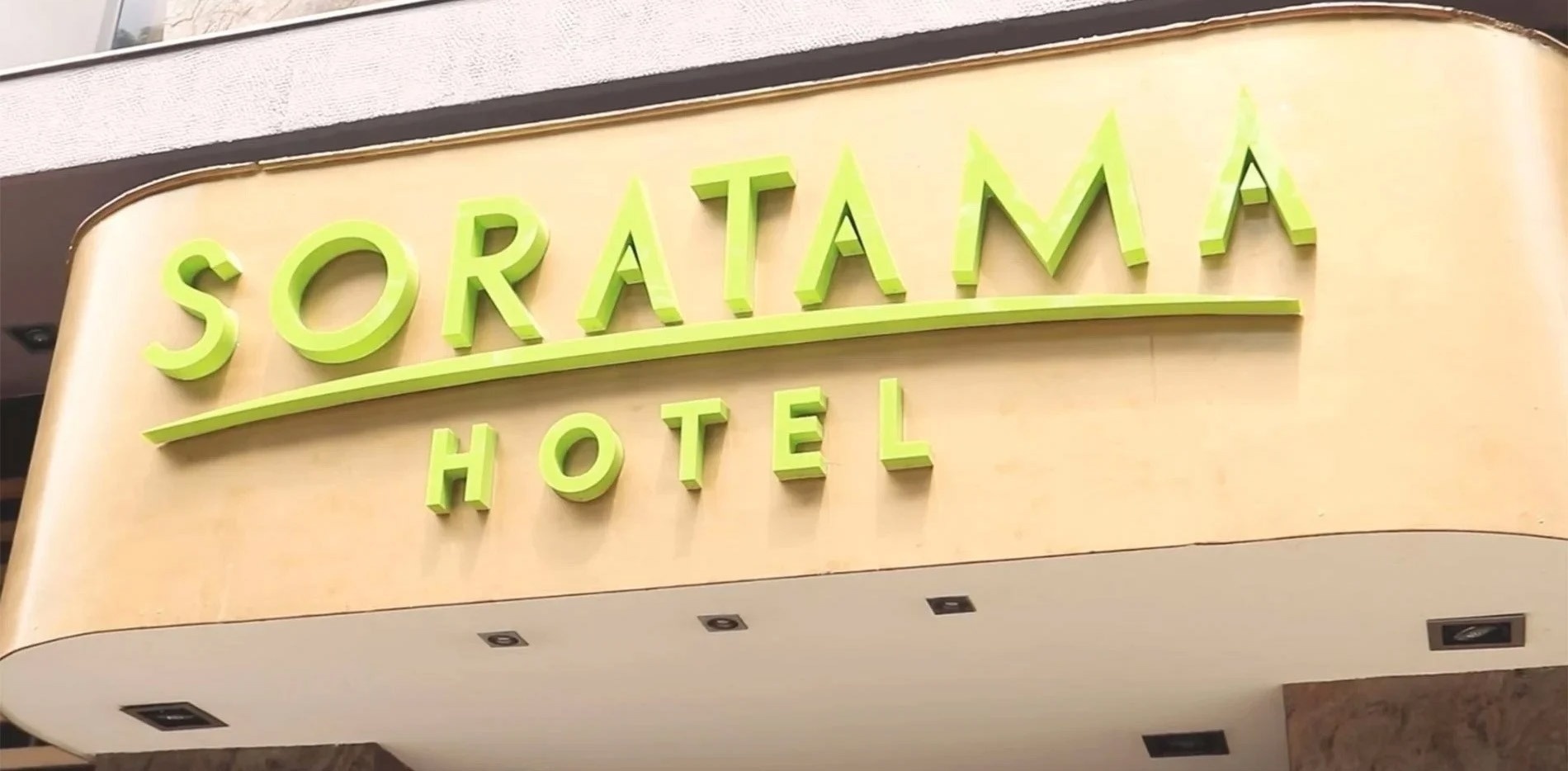 un cartel de un hotel con letras verdes y amarillas