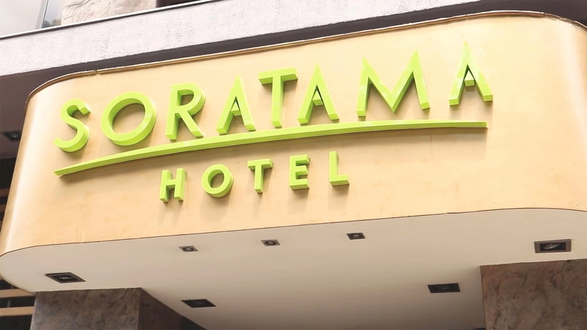 un cartel verde y amarillo para soratama hotel