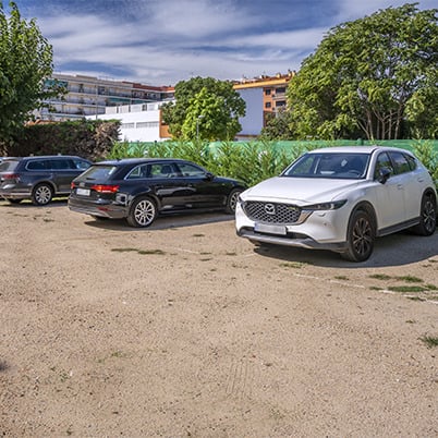 White Mazda SUV parked at a hotel with other cars and trees. Sorrabona