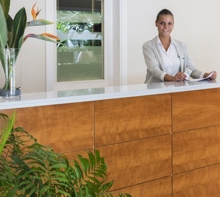 a woman sitting at a reception desk holding a passport