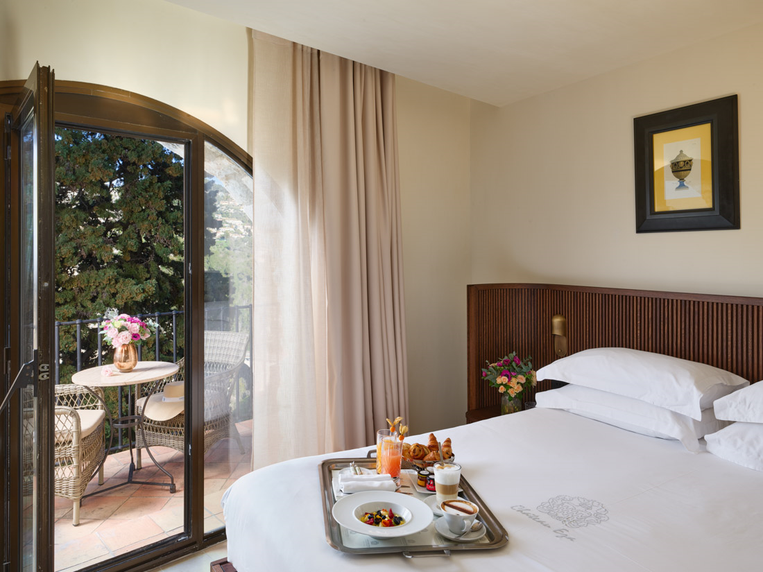 ein Hotelzimmer mit einem Bett und einem Tablett mit Essen darauf