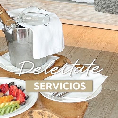 una mesa de madera con platos de frutas y una botella de champán