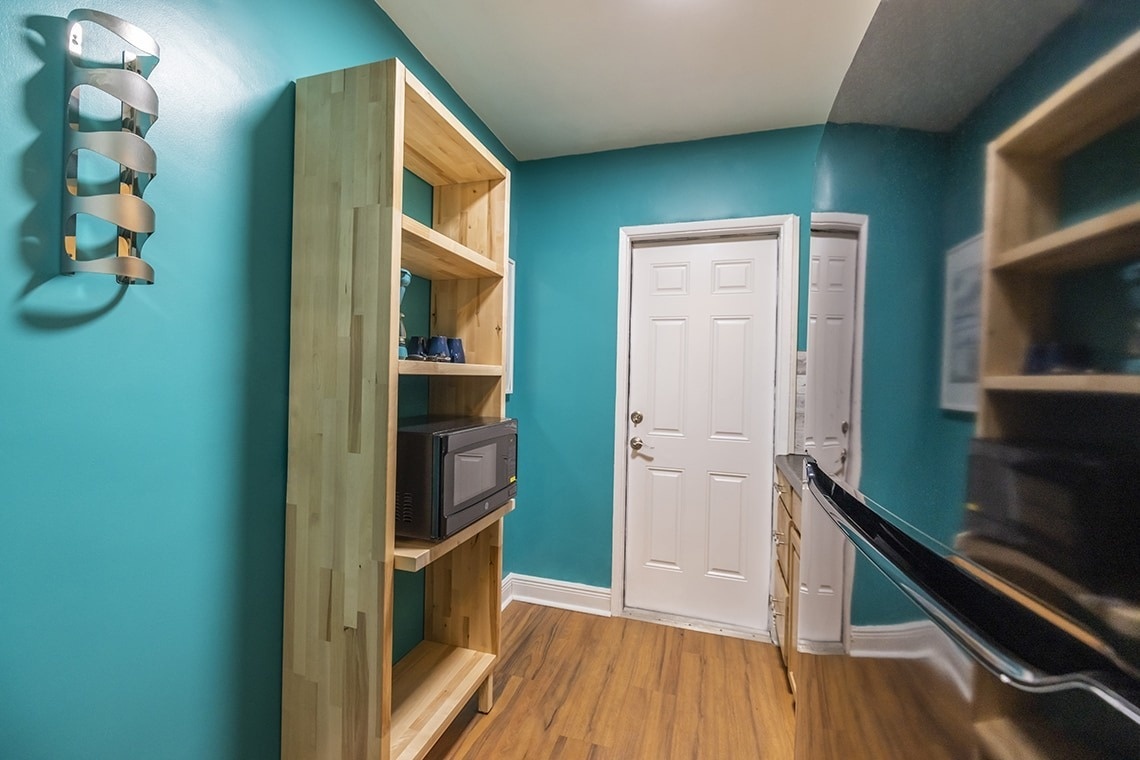 a shelf with a microwave on it in a kitchen