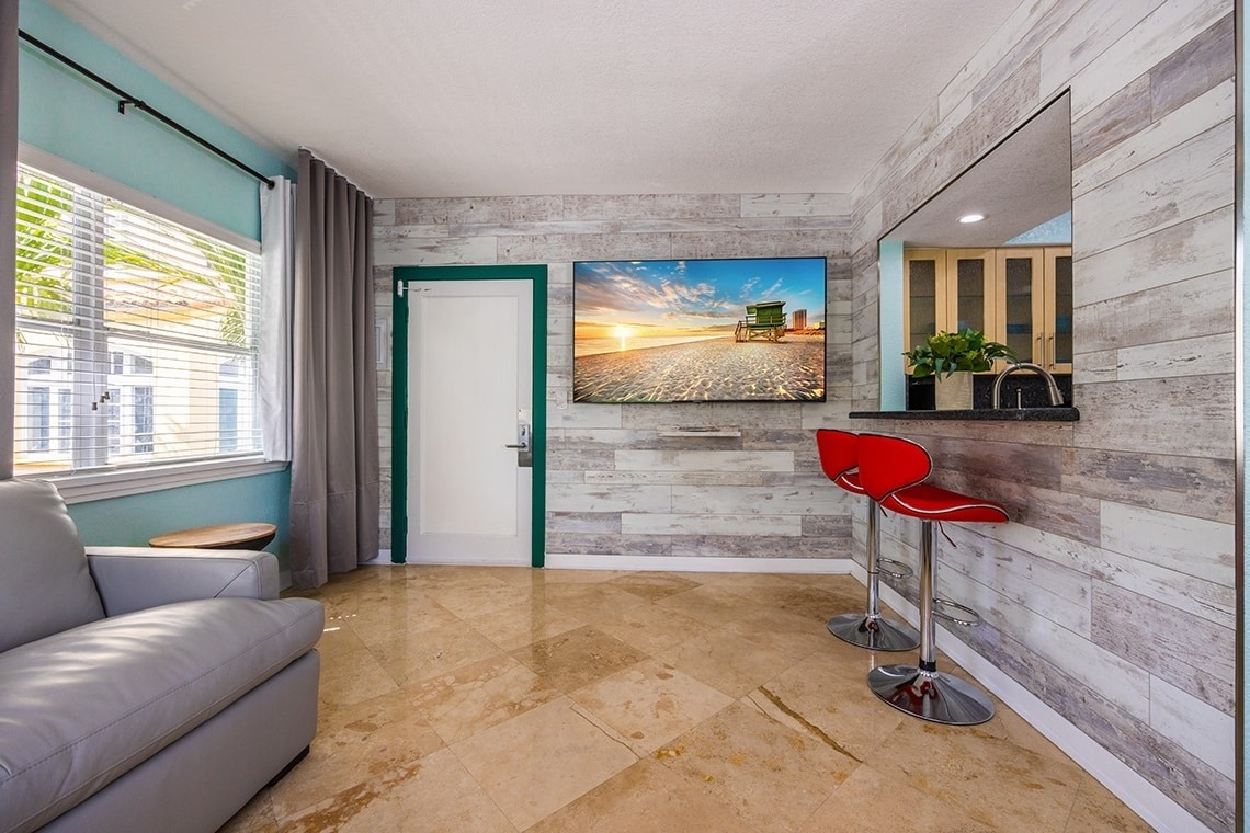a living room with a couch and two red bar stools