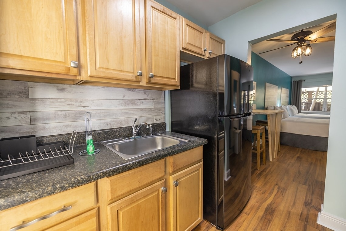 a kitchen with a sink and a black refrigerator