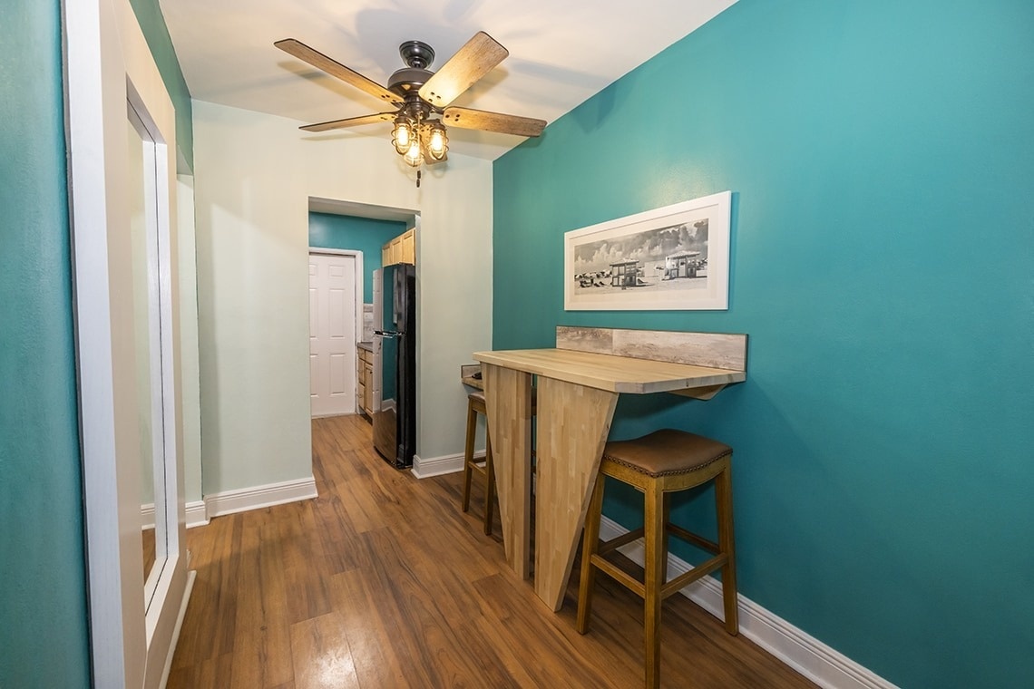 a hallway with blue walls and a ceiling fan