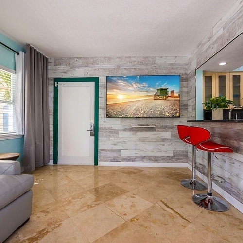 a living room with a couch and two red bar stools