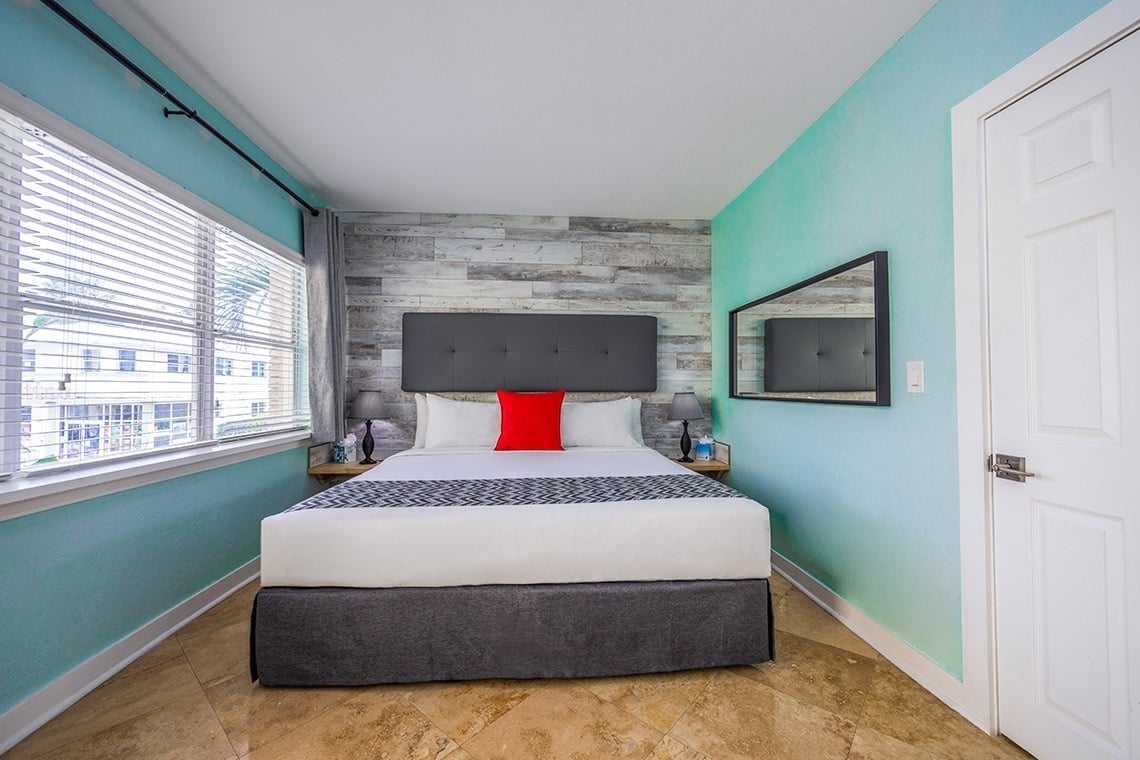 a small bedroom with a bed and a mirror