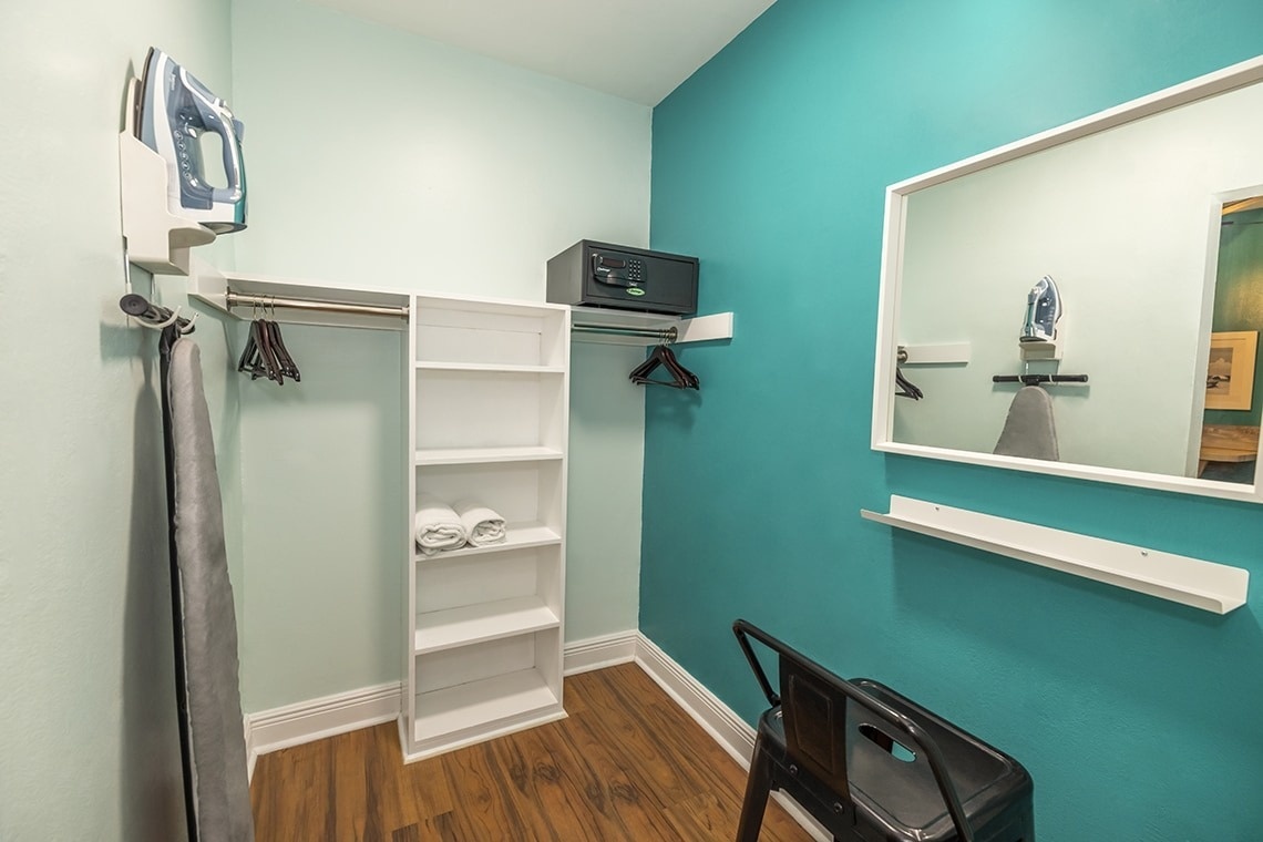 a small closet with a safe and a mirror