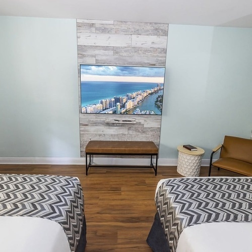 a hotel room with two beds and a flat screen tv