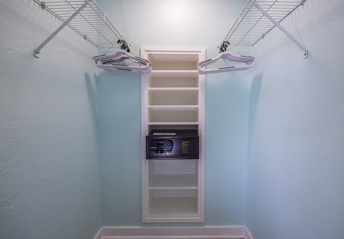 a walk in closet with shelves and a safe