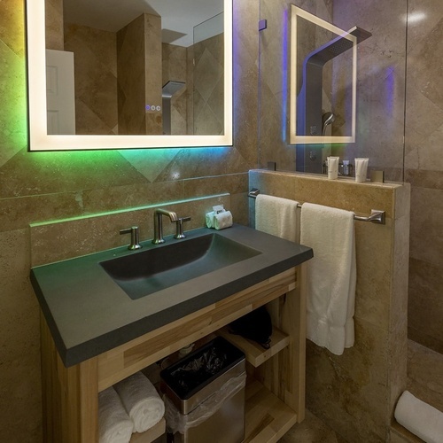 a bathroom with a sink a mirror and a trash can