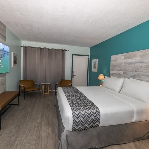 a hotel room with a king size bed and a flat screen tv