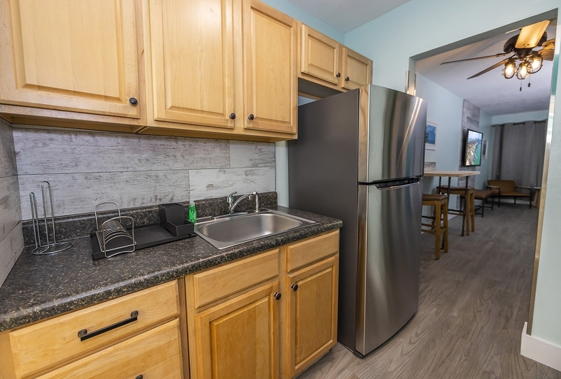 a kitchen with a sink and a stainless steel refrigerator