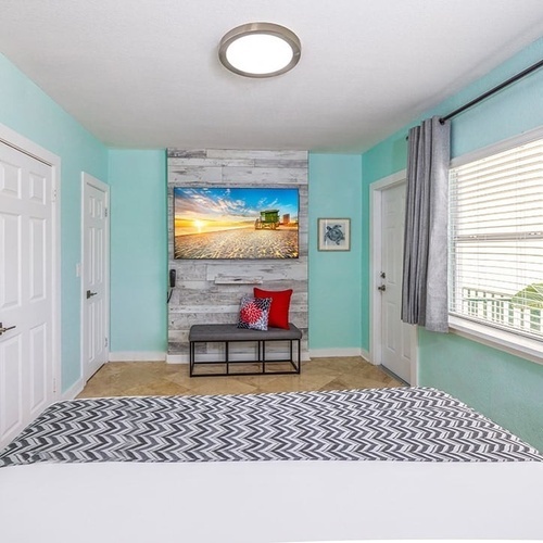 a bedroom with a bed and a painting on the wall