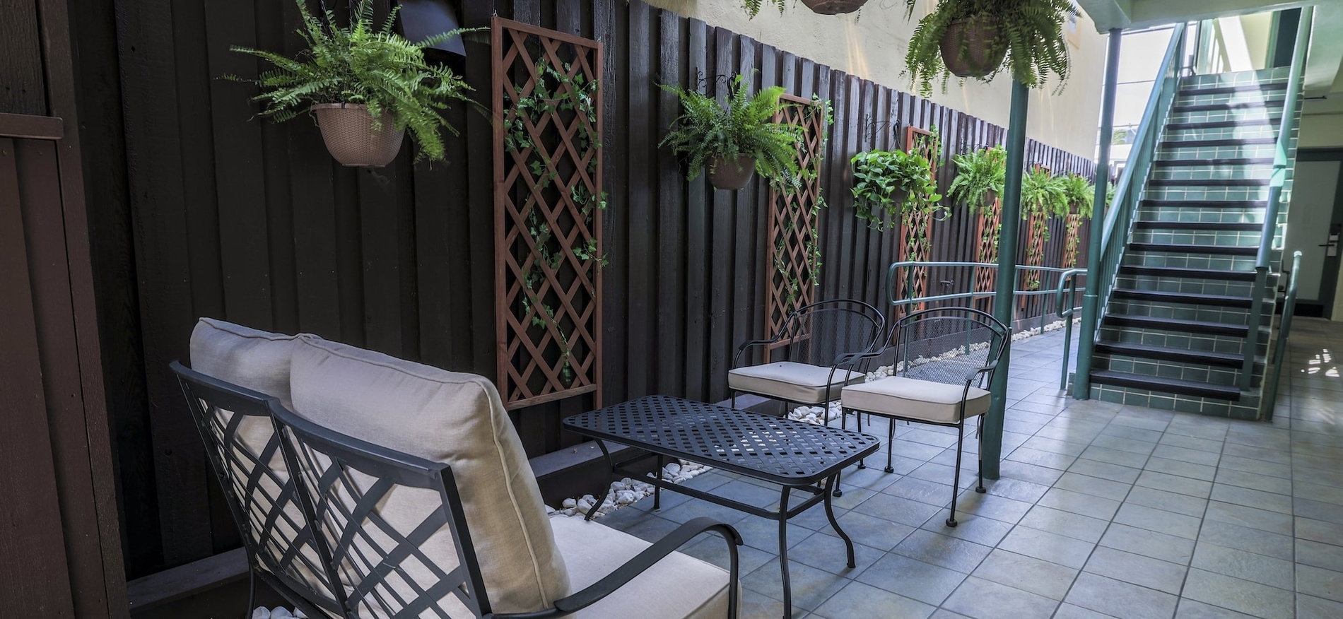 a patio with a couch and chairs and potted plants