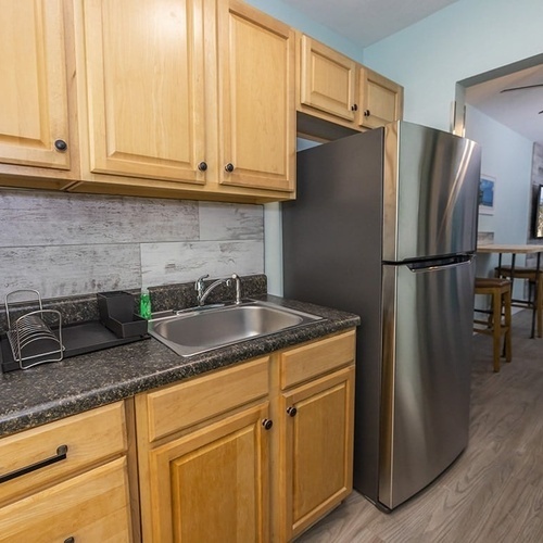 a kitchen with a sink and a stainless steel refrigerator