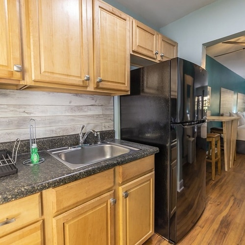 a kitchen with a sink and a black refrigerator