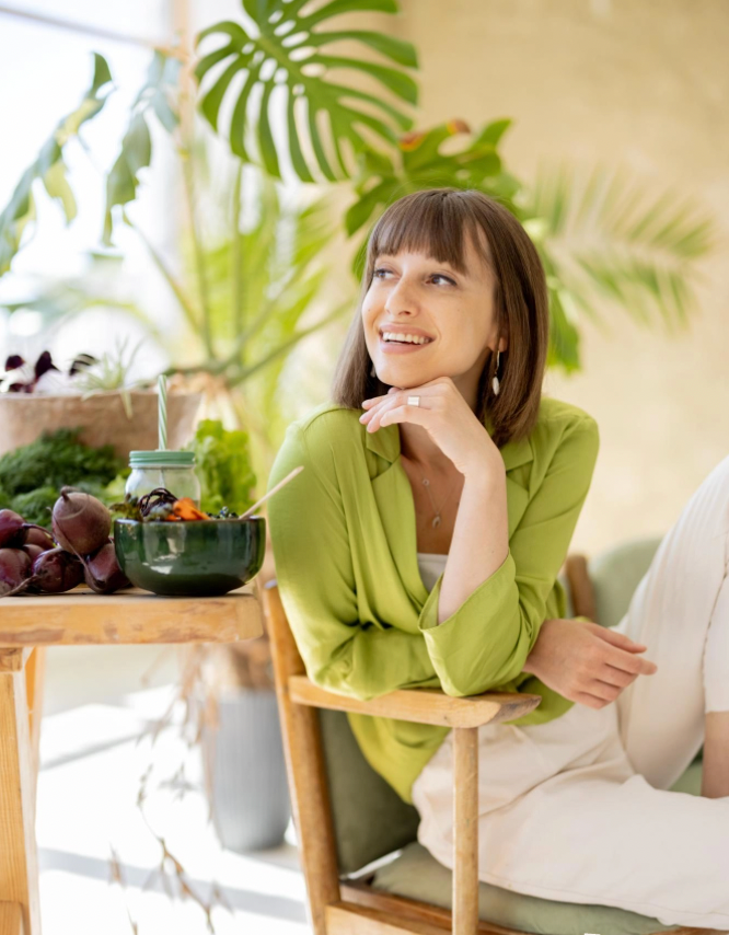 una mujer sostiene un trozo de ostra encima de un cóctel .